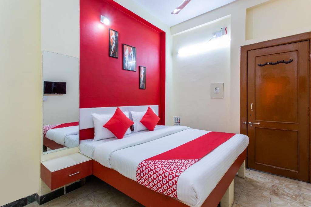 DewāsHotel Santushti的卧室设有红色的墙壁和一张床