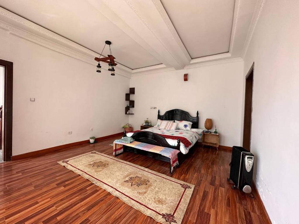 亚的斯亚贝巴Kebena spacious room with private jacuzzi and walk in closet的一间卧室配有一张床,铺有木地板