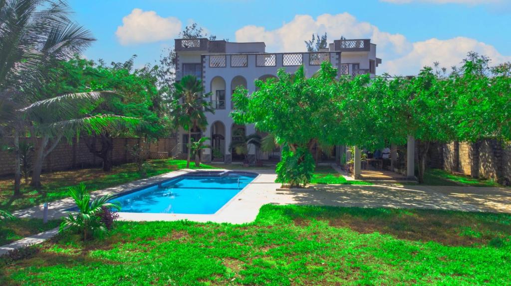 基利菲Amani House的一座带游泳池和树木的房子