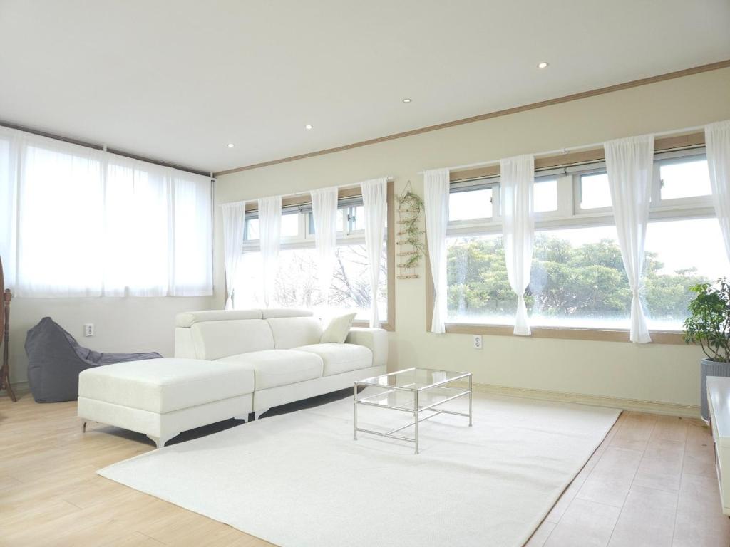丽水市Canada Mung Village的客厅配有白色的沙发和窗户。