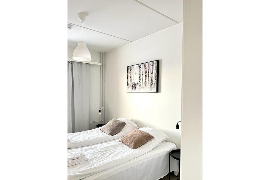 奥卢奥卢家居庭公寓的白色的客房设有床和窗户。