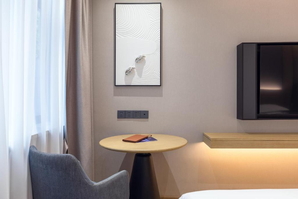 深圳漫时酒店(深圳大学科技园店)的客房设有小桌子和电视。