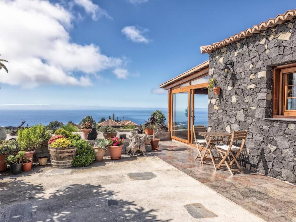洛斯·亚诺斯·德·阿里丹Casa Pedrito - Cozy House, dreamy Terrace & Sea views的石头房子,设有配有桌椅的庭院