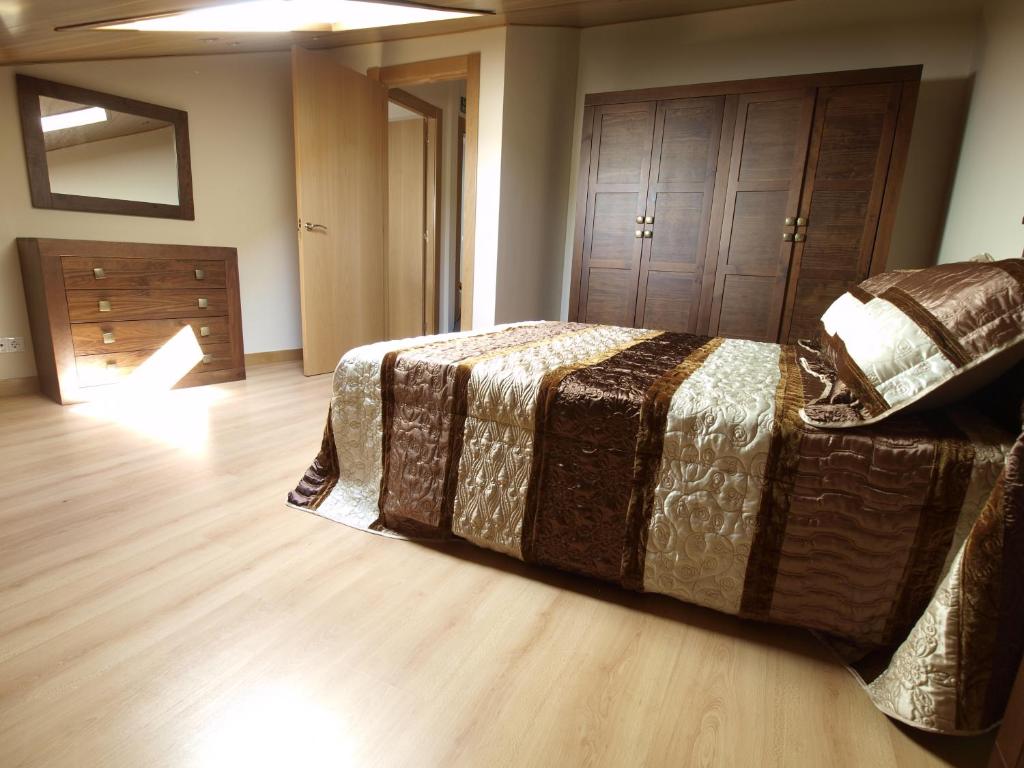 桑托多明戈德锡洛斯Casa Rural El Cipres的一间卧室配有一张床,铺有木地板