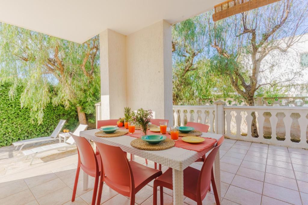 托雷桑塔萨宾娜Villa Brigida a Torre Santa Sabina的一间带桌子和红色椅子的用餐室