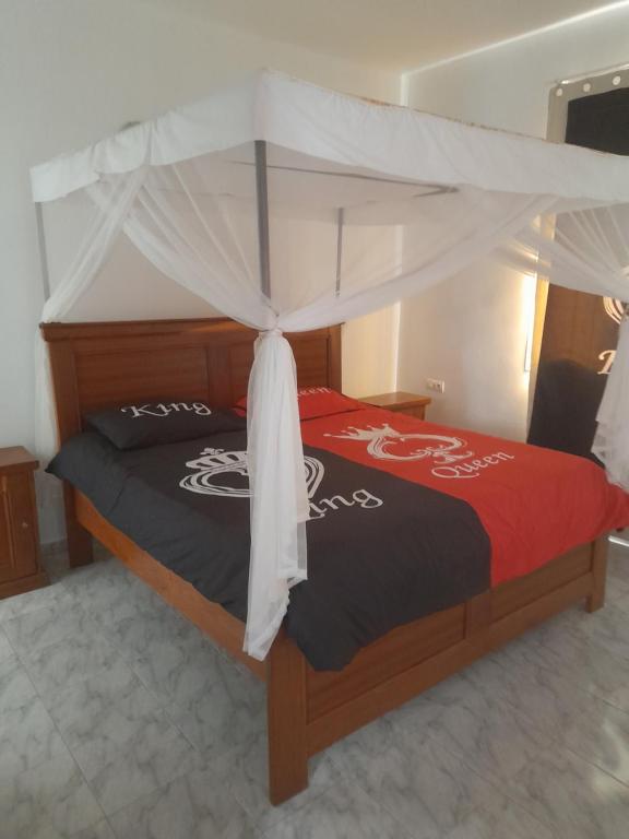 索蒙La doré du Sénégal的一间卧室配有一张带天蓬的床
