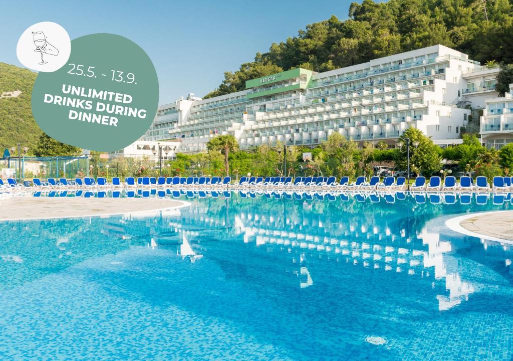 拉巴克常春藤酒店 - 马斯利尼察酒店及度假村的一座大型游泳池,其建筑背景为:
