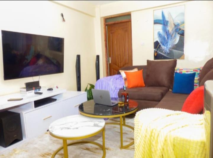 尼耶利Moh Cabins的客厅配有沙发和带笔记本电脑的桌子