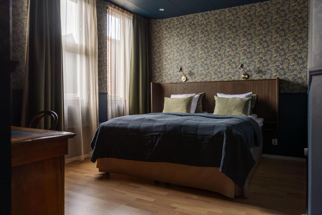 JonseredGibsons Hotell的一间卧室配有一张带木制床头板的床