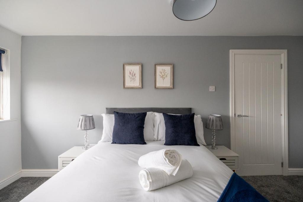 蒂斯河畔斯托克顿Woodham House By Horizon Stays的卧室配有带蓝色枕头的大型白色床