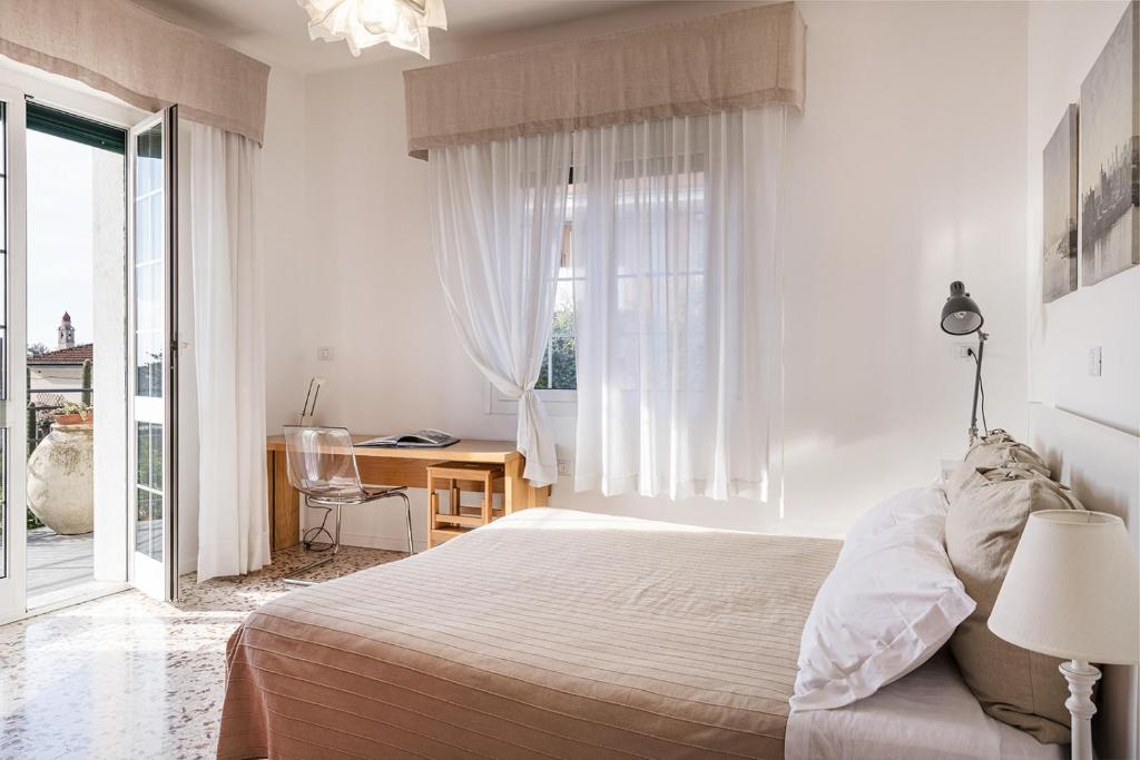 圣巴特罗摩艾美尔Casa delle Zagare的白色的卧室设有床和窗户