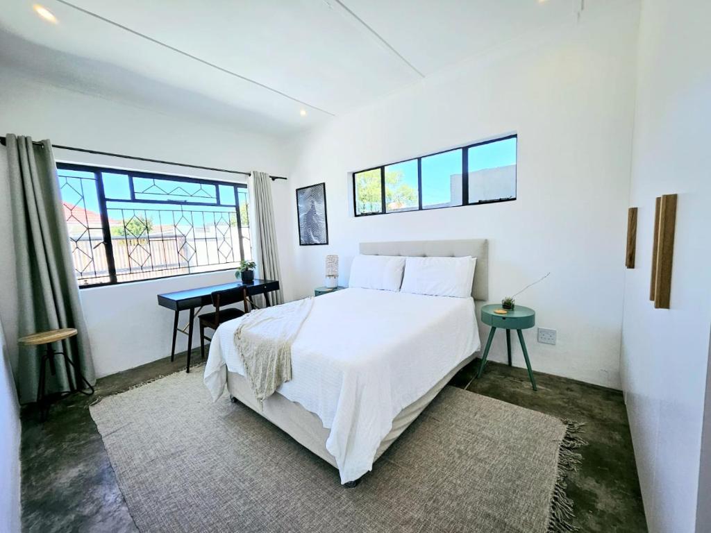 开普敦Private 2 Bed Guest Suite with Garden的白色卧室配有一张大床和一张书桌