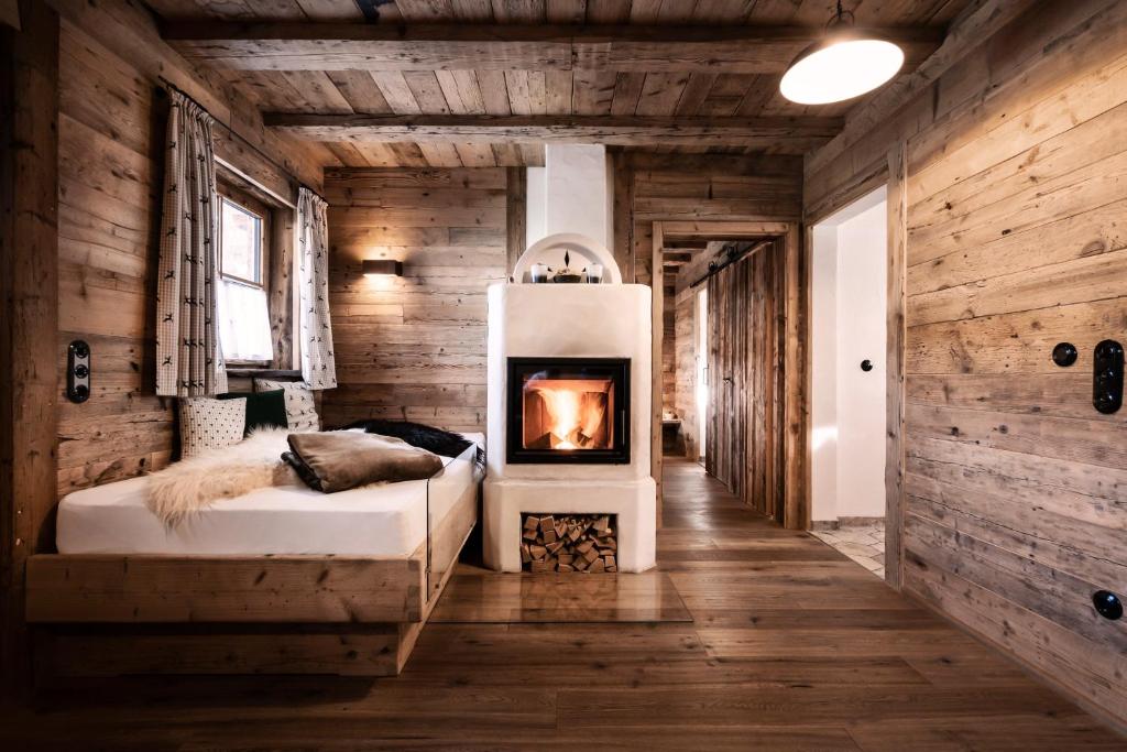 巴特欣德朗Alpin Chalets Oberjoch - Luxus Unterkunft mit privatem SPA und Zugang zu 3000 qm SPA Panoramahotel Oberjoch的一间卧室设有一张带壁炉的床。