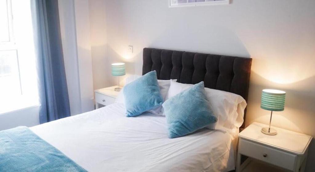 伦敦Wood Green Budget Rooms - Next to Mall & Metro Station - 10 Min to City Center的一间卧室配有一张带蓝色枕头的床。
