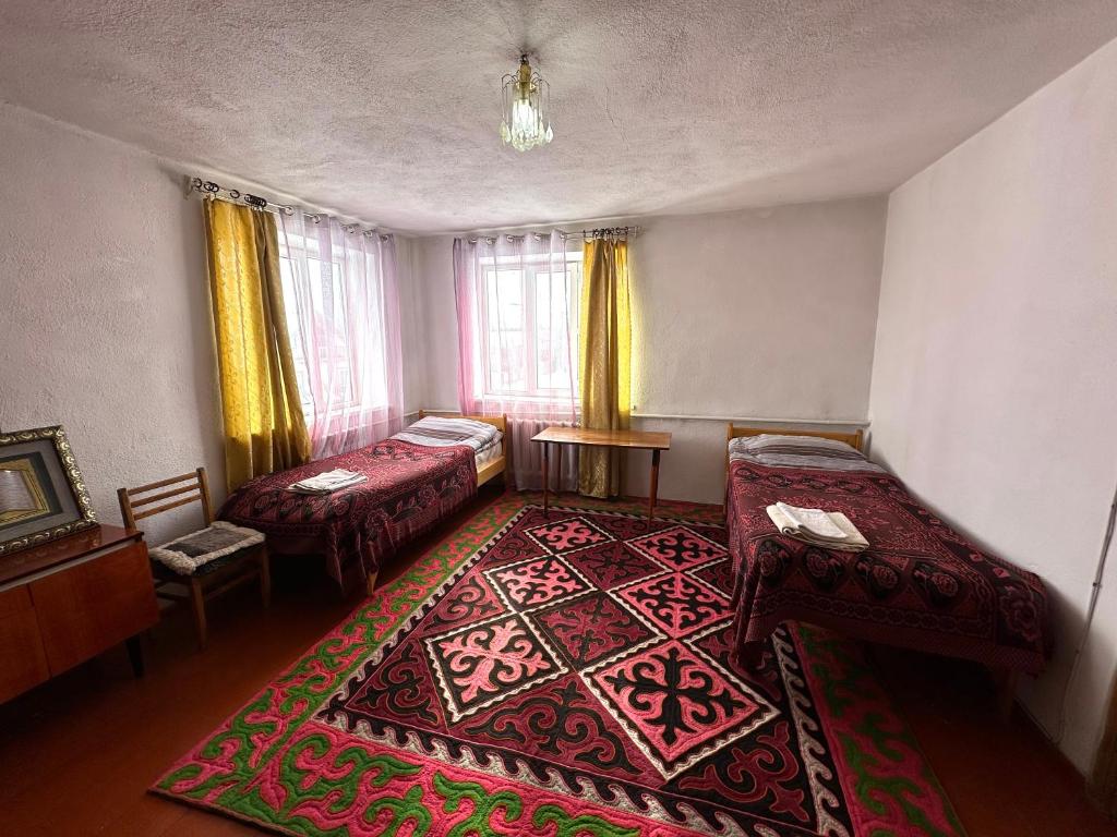 OrgochorKayyr Guest House的一间设有两张床的房间和一张地毯