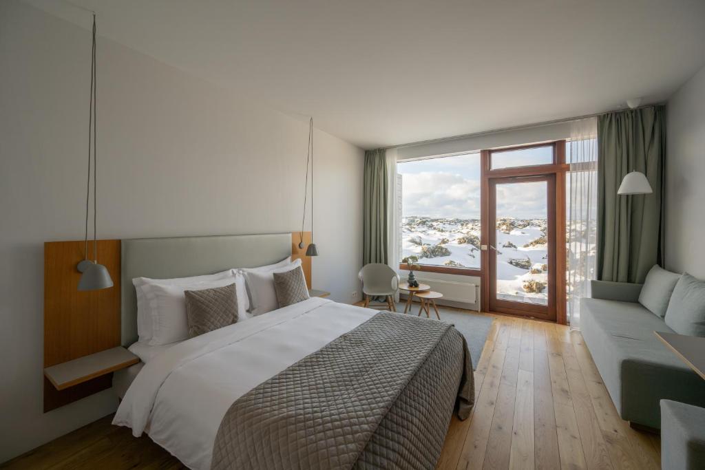 格林达维克Silica Hotel at Blue Lagoon Iceland的一间卧室配有一张床、一张沙发和一个窗口