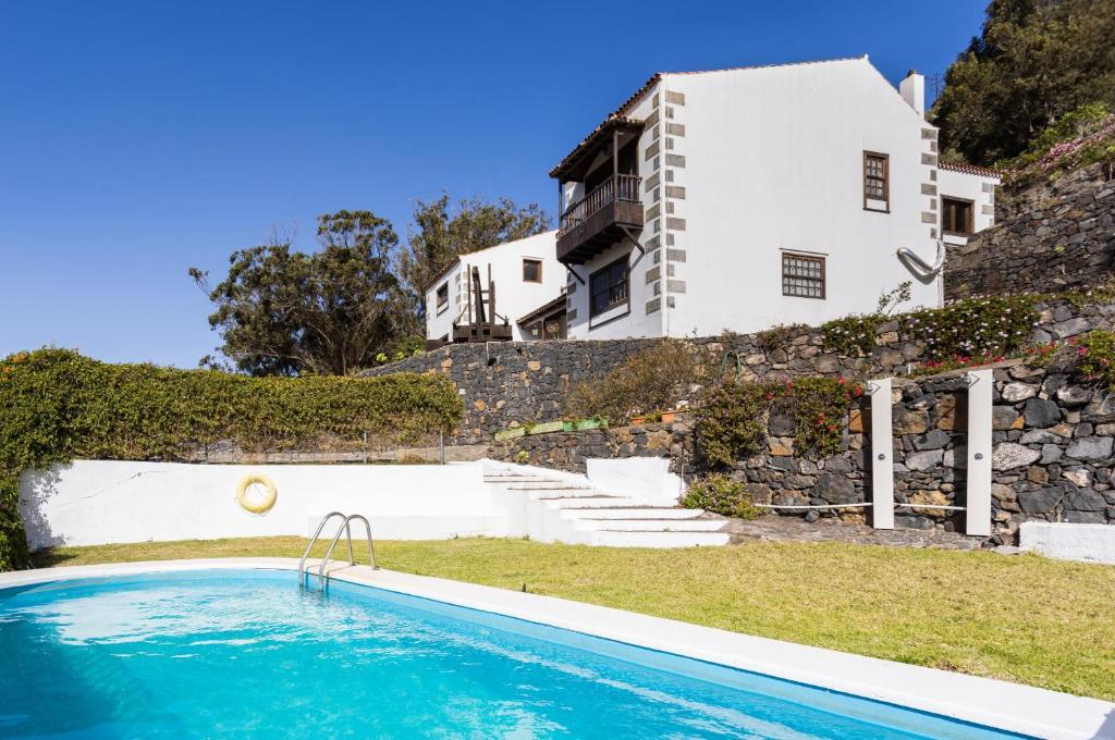 特格斯特Finca Los Geranios的房屋前有游泳池的房子