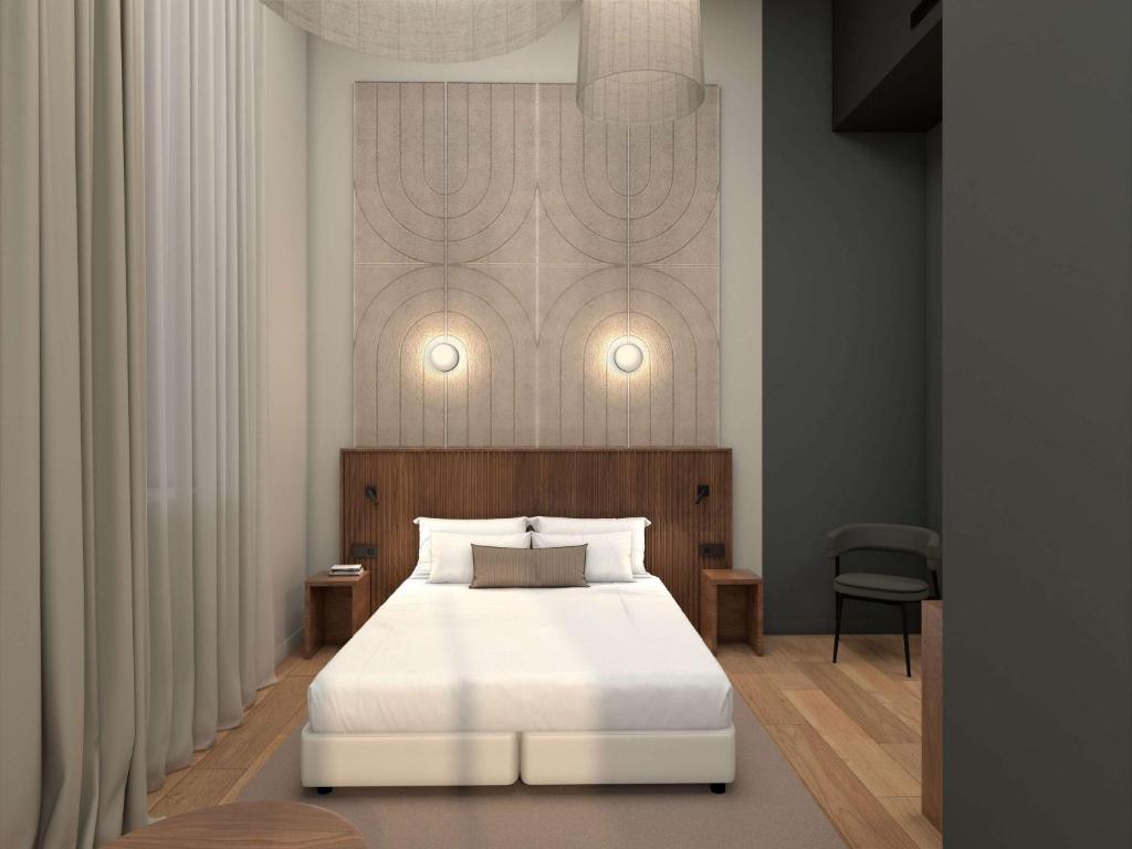里昂Hotel et Spa Fort St Laurent Lyon - Handwritten Collection的一间卧室配有一张带白色床罩的床