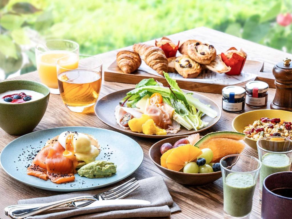 南部町Grand Mercure Wakayama Minabe Resort & Spa的一张木桌,上面放着食物和饮料