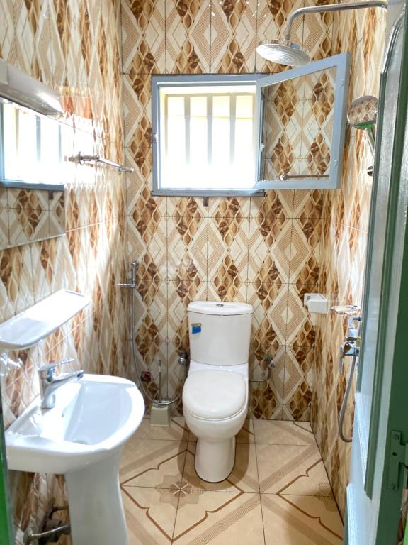 瓦加杜古Mini villa meublée pour vos séjours的一间带卫生间和水槽的浴室