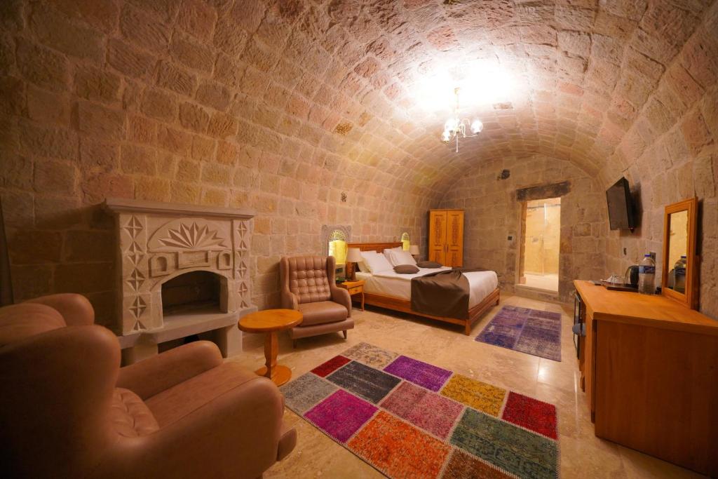 格雷梅Secret Hill Cave Suites的客厅设有一张床和一个壁炉