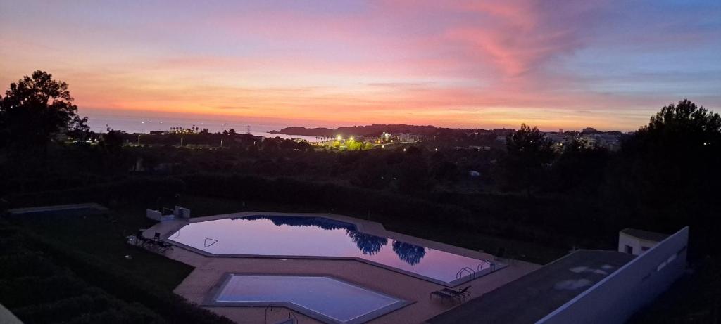 波尔蒂芒Apartamento Mar a Vista的享有日落美景,设有游泳池