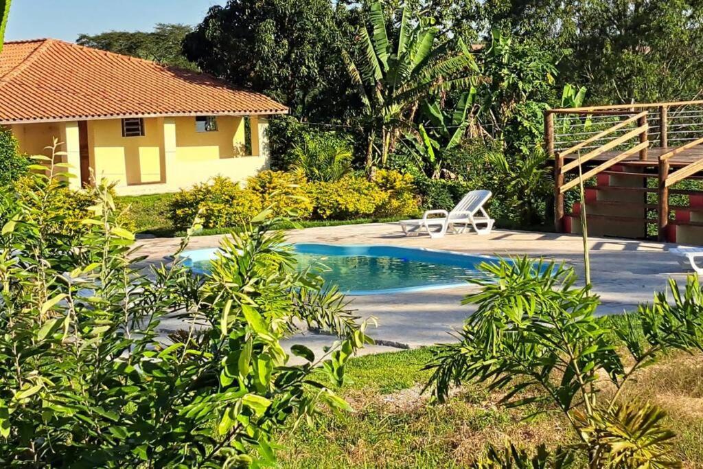 圣代佩德罗Casa em sítio à beira do Rio Piracicaba c/ piscina的房屋旁带椅子的游泳池
