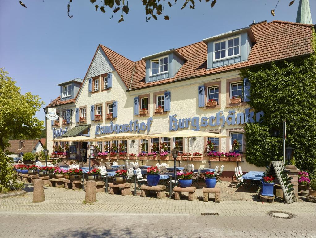 凯撒斯劳滕Hotel & Restaurant Burgschänke的前面设有桌椅的建筑