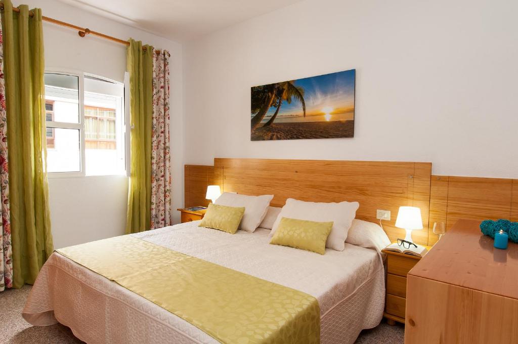 大加那利岛拉斯帕尔马斯卡萨公寓的一间卧室配有一张大床、两盏灯和一个窗户。