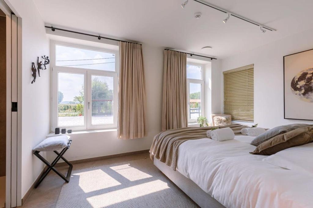 布鲁日Lord - Charming double room at ranch "De Blauwe Zaal"的一间卧室设有两张床和两个窗户。