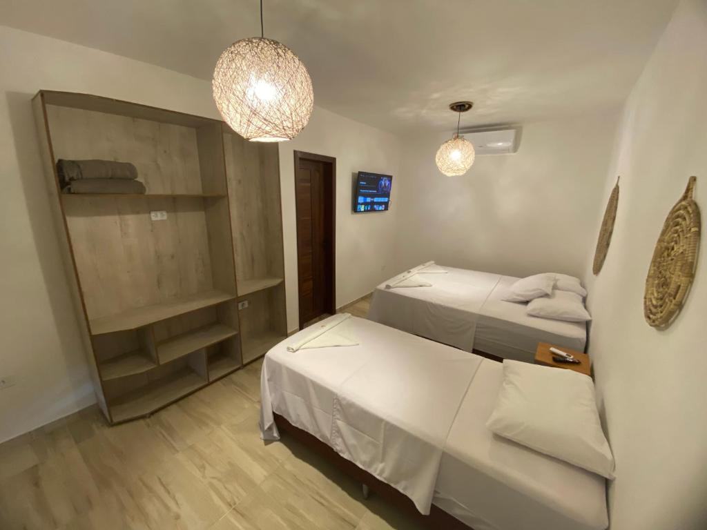 巴雷里尼亚斯Pousada Terra das Águas Barreirinhas的一间小房间,配有两张床和一张沙发