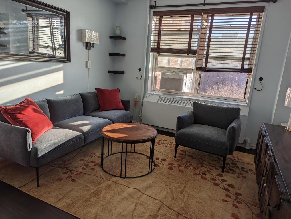 纽约Fully renovated Manhattan gem的客厅配有沙发、两把椅子和一张桌子