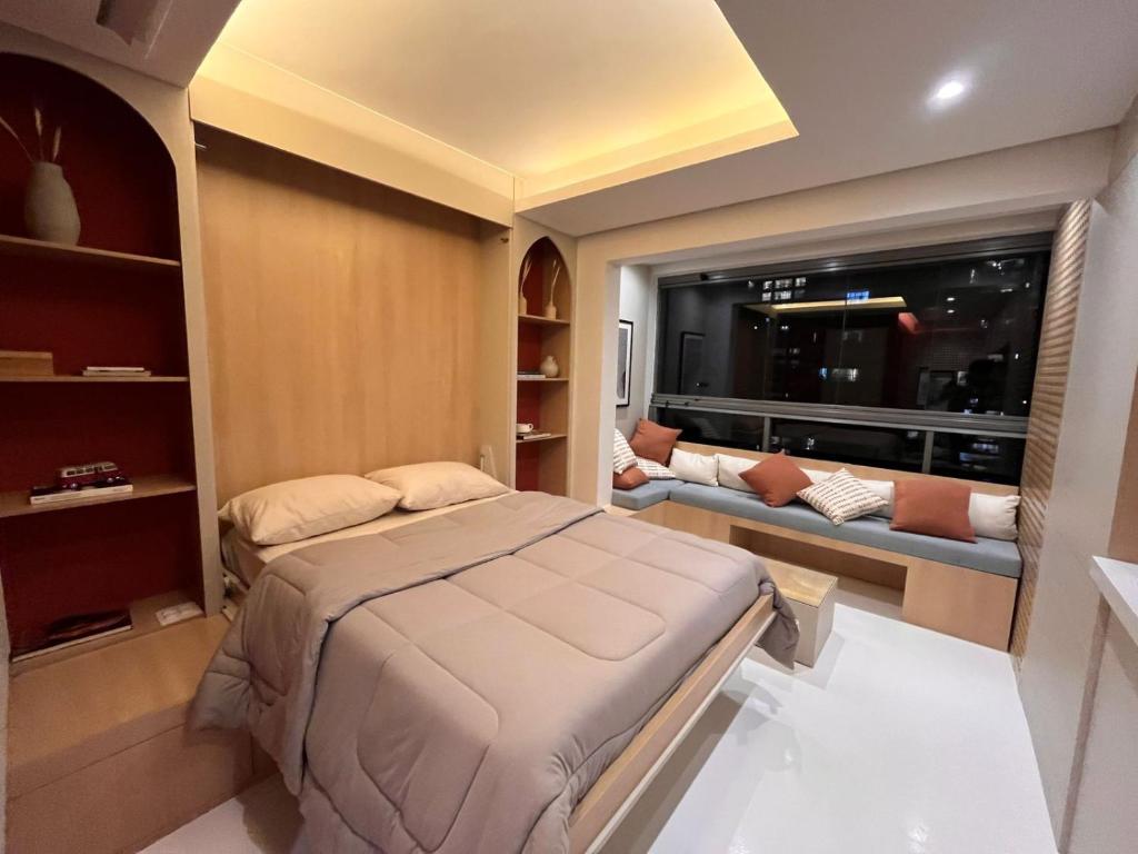 圣保罗MARCOLINI - Flat Luxo Bela Cintra的一间卧室配有一张床、一张沙发和一个窗口