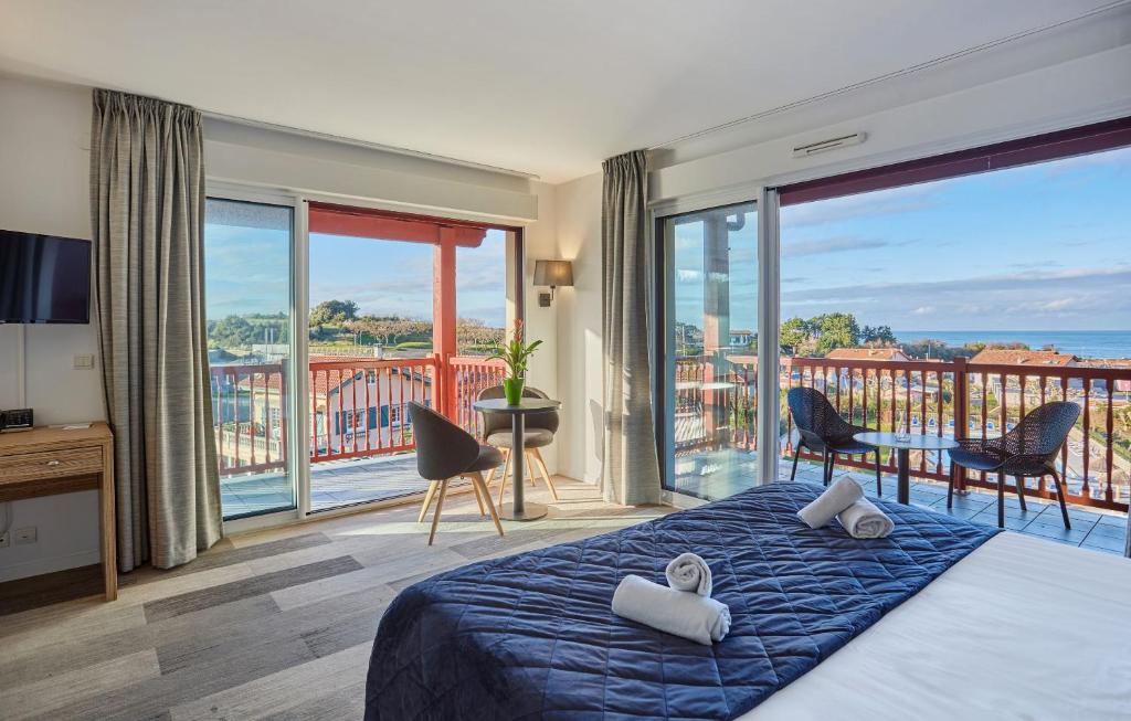 圣让-德吕兹Hôtel Prestige Odalys Erromardie的一间卧室配有一张床,享有海景