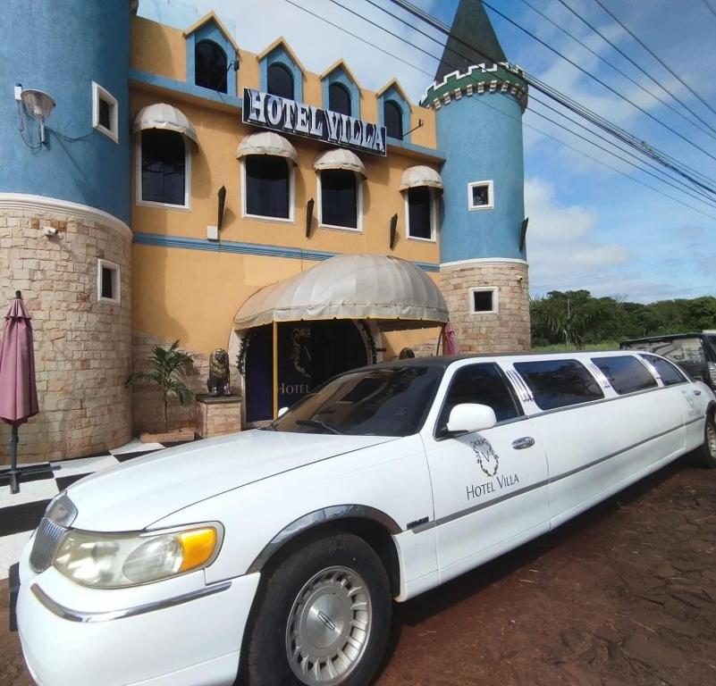 San Juan del ParanáHotel Villa的停在大楼前的白色豪华轿车