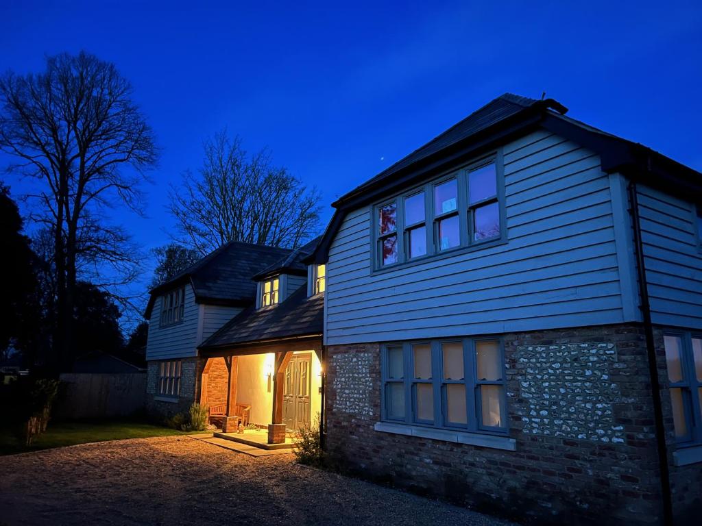 LavantFlint House, Rew Lane, Chichester的夜晚有灯的房子