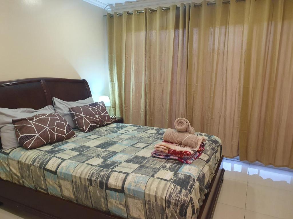 碧瑶大地广场梅加塔住宅公寓的一间卧室配有一张带毯子和枕头的床。