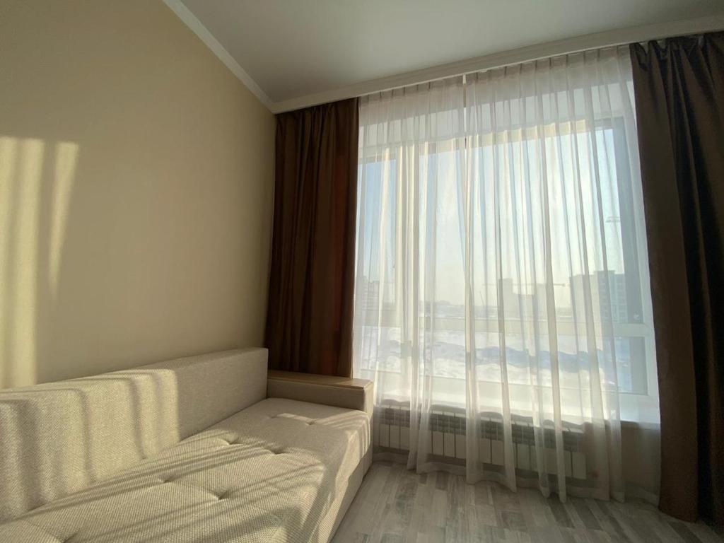 PrigorodnyyЖК Sati Club House的客房设有带沙发和床的大窗户。