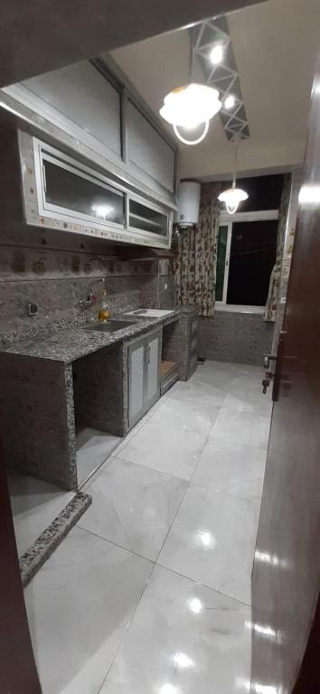 卡萨布兰卡Appart casa的一间铺有白色大瓷砖地板的大厨房