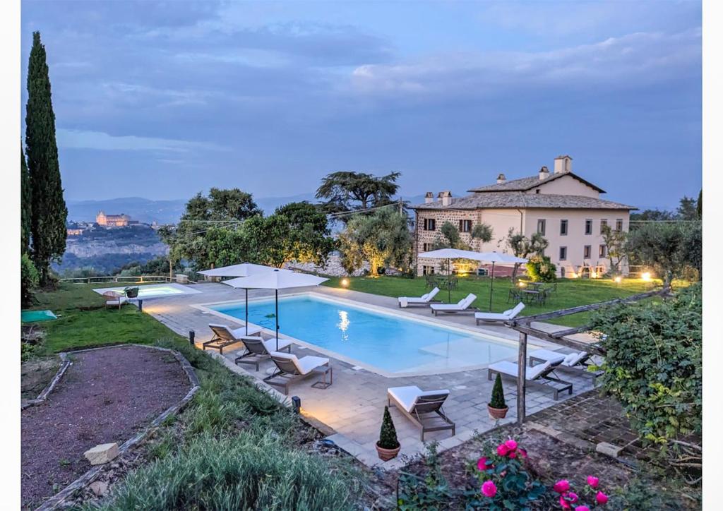 奥维多Pietra Campana Italian Villa Orvieto的一个带椅子的游泳池和一个背景房子