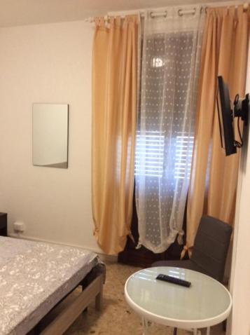 比萨CasaGiulia2Apartament的一间卧室配有一张床、一张桌子和一个窗户。