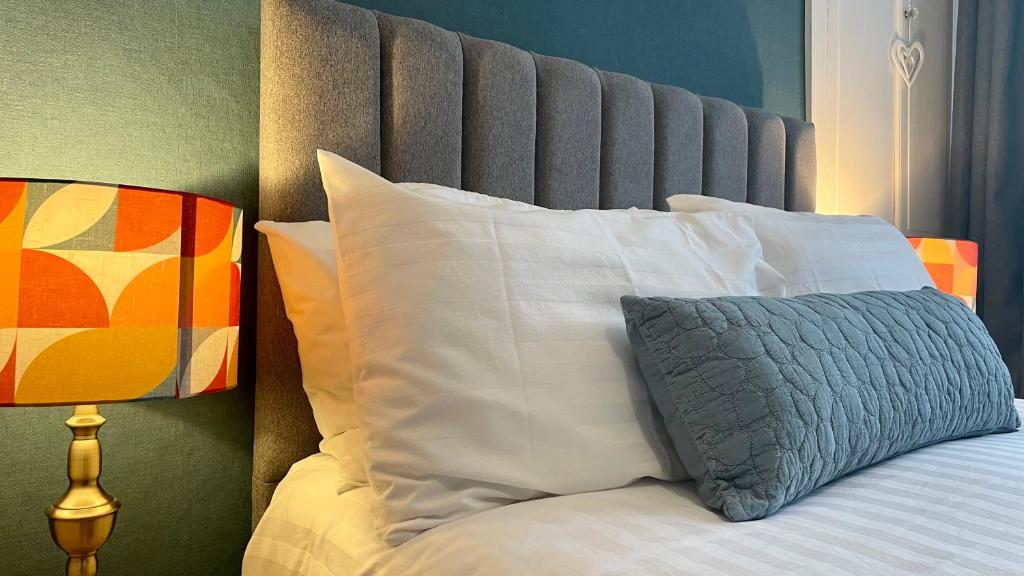 安布尔塞德拉塞特房屋酒店的一张带白色枕头的床和一个灰色床头板