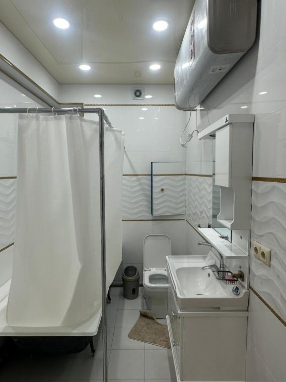 杜尚别The Rudaki Home stay的白色的浴室设有卫生间和水槽。