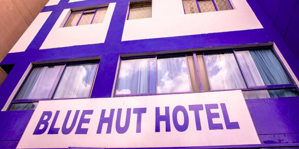 内罗毕Blue Hut Hotel的大楼一侧的蓝色热酒店标志
