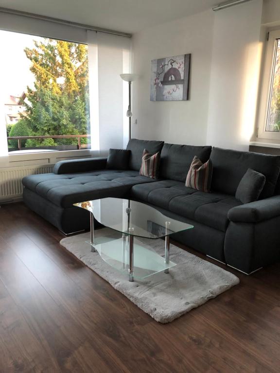 施万高Ferienwohnung Alpenrose的客厅配有黑色沙发和玻璃桌