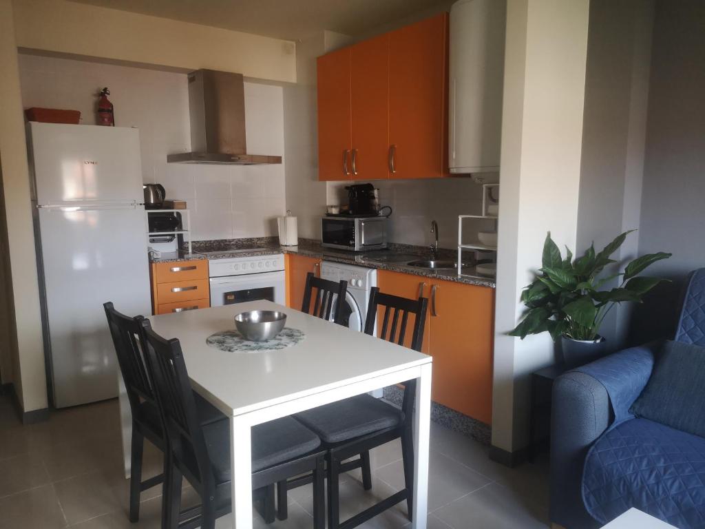科鲁韦多Céntrico apartamento en Corrubedo的厨房配有白色的桌椅和蓝色的沙发。