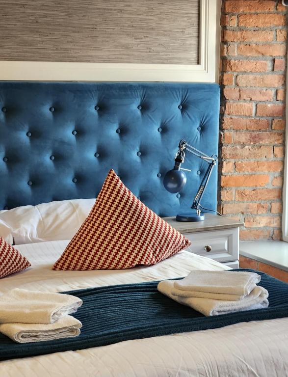梅努斯Maynooth Serviced Studios的一张带蓝色床头板和台灯的床