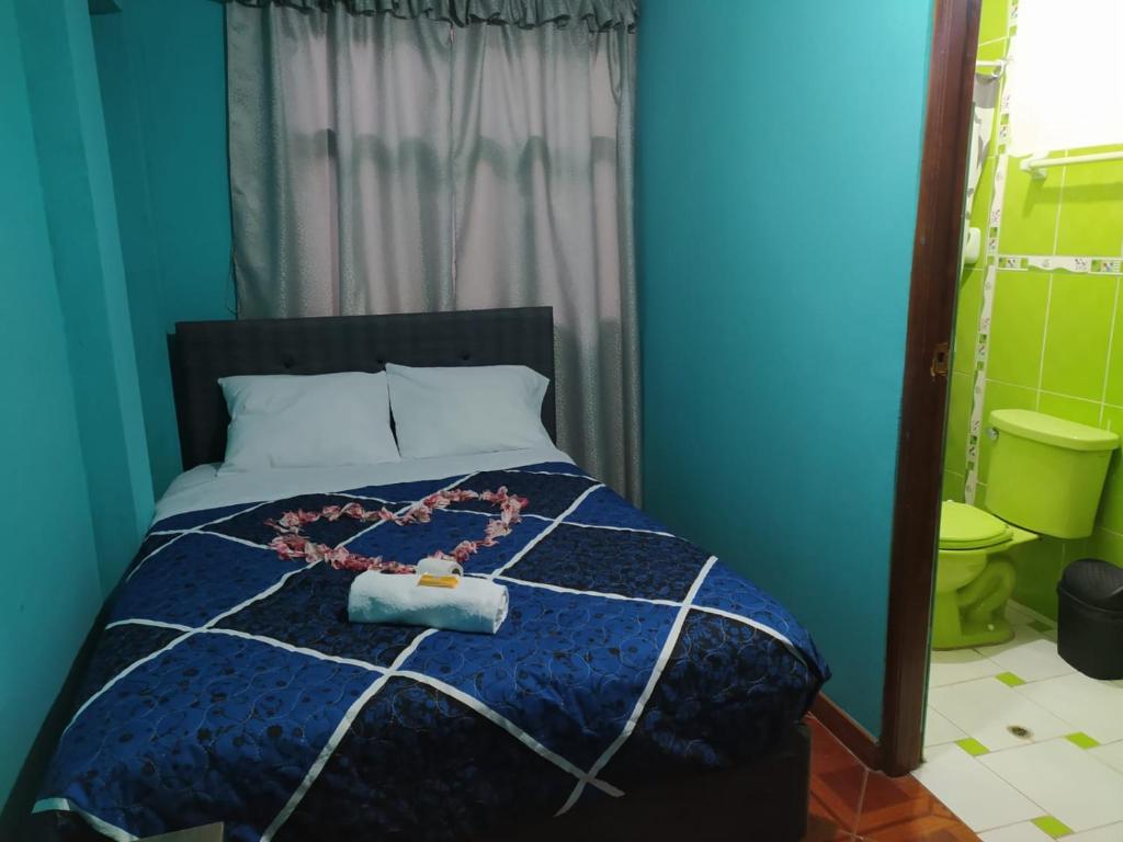 阿亚库乔HOSPEDAJE EL ARCO的蓝色卧室,配有带项链的床