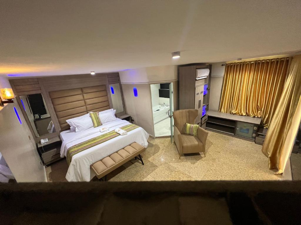拉各斯Ikeja Airport View的一间大卧室,配有一张大床和一把椅子