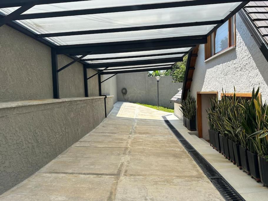 布卡拉曼加Casa Chalet en Lagos del Cacique的遮阳篷,遮阳篷,在植物林立的建筑中